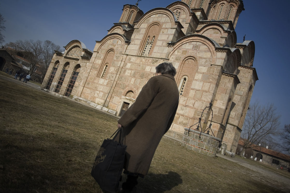 A Serb woman walks past the old monastery in the serb enclave of Gracanica.