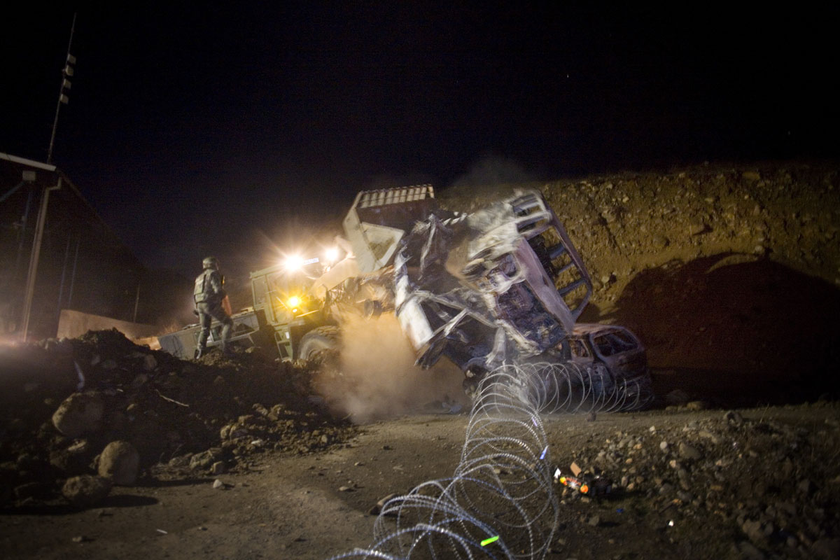 A KFOR bulldozer clears burned vehicles at the Jarinje border post in northern Kosovo after an attack by angry Serbs.